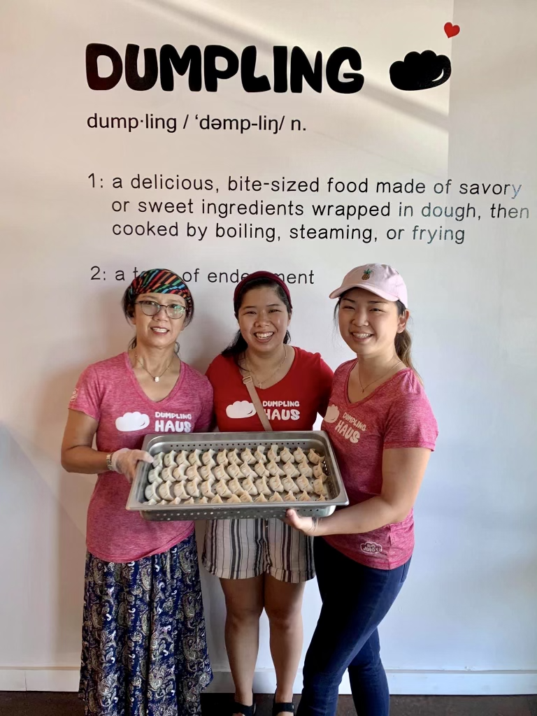 Three Woman Holding Tray of Dumplings