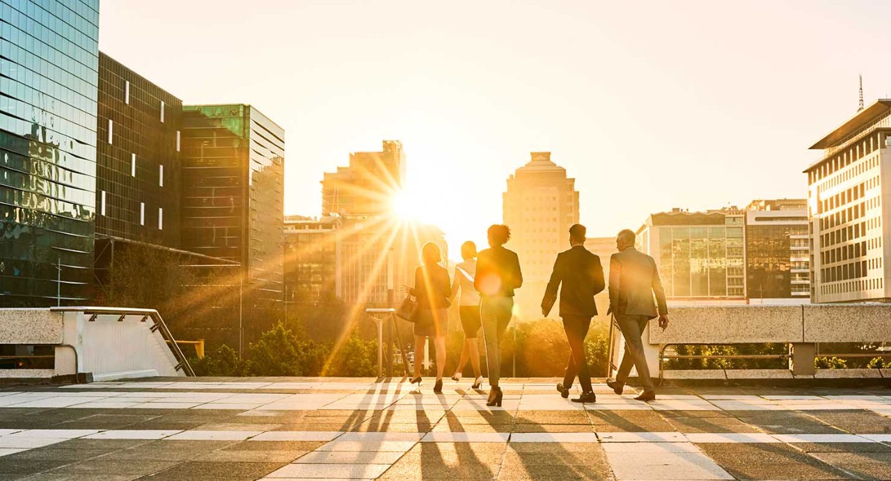Municipal Underwriting Group of city workers walking with cityscape in background.