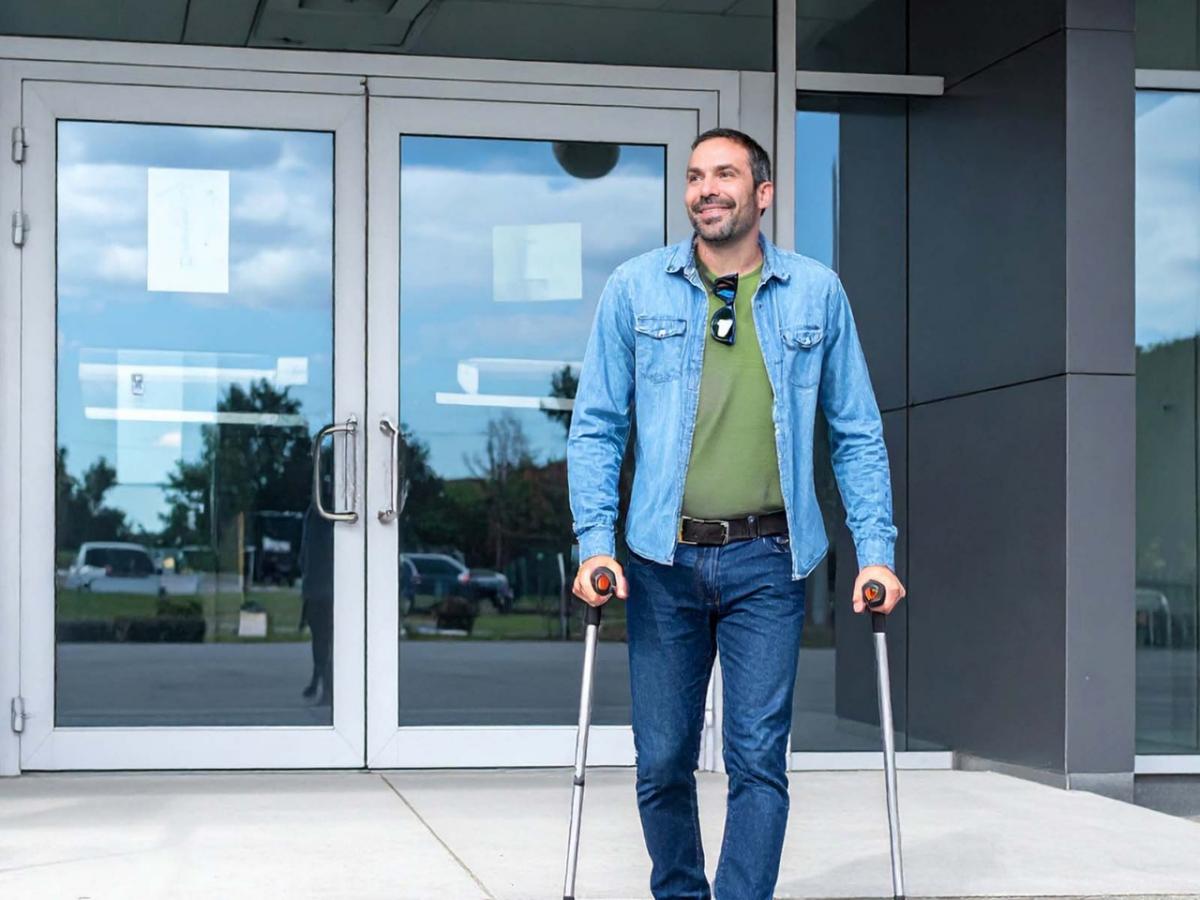 Man in a wheelchair accesses his safe deposit box at a bank