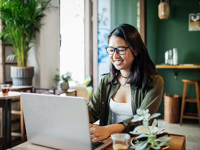 Woman working on her laptop in a cafe
