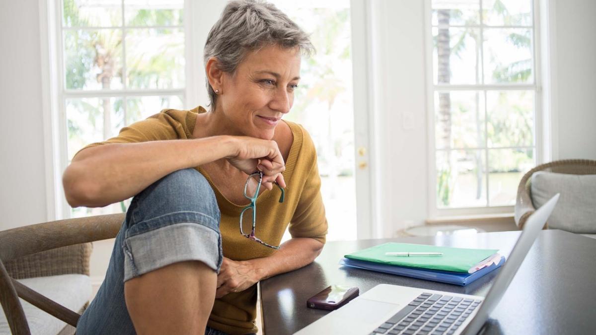 SoftwareProtection_ImageBlock_WomanUsingLaptopInLivingRoom Woman using laptop in living room
